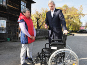 Артюхов А.В. вручает коляску матери инвалида